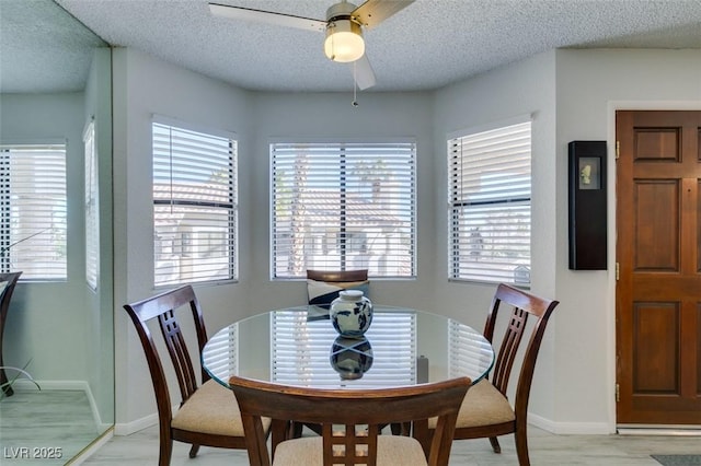 dining area with ceiling fan and a textured ceiling