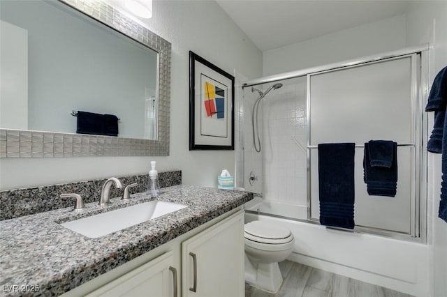 full bathroom with shower / bath combination with glass door, hardwood / wood-style flooring, toilet, and vanity