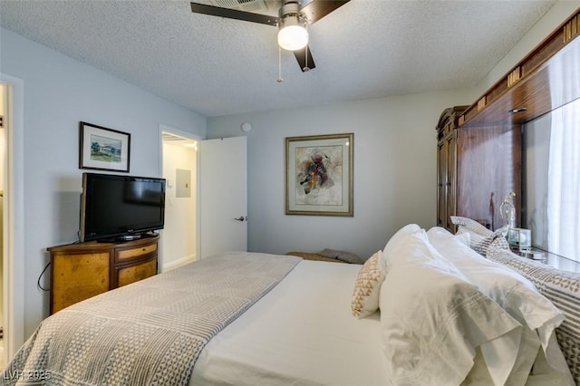 bedroom featuring multiple windows, a textured ceiling, and ceiling fan