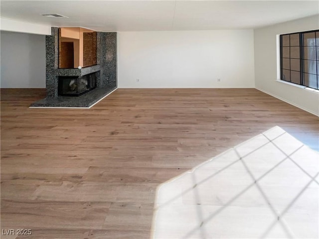 unfurnished living room featuring hardwood / wood-style floors and a fireplace