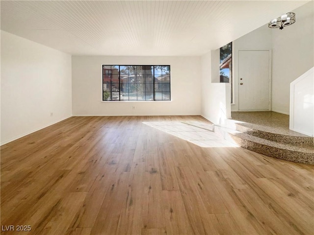 empty room featuring a chandelier and wood-type flooring