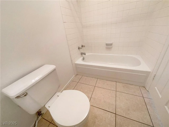 bathroom featuring toilet, tiled shower / bath combo, and tile patterned flooring