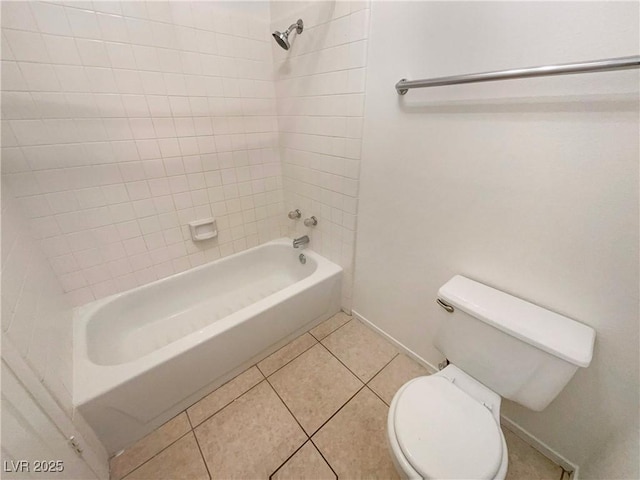 bathroom featuring toilet, tiled shower / bath combo, and tile patterned floors