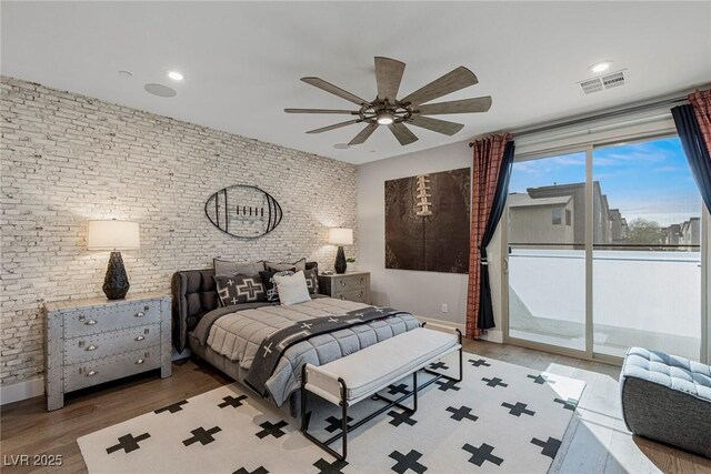 bedroom featuring ceiling fan, access to outside, brick wall, and hardwood / wood-style flooring