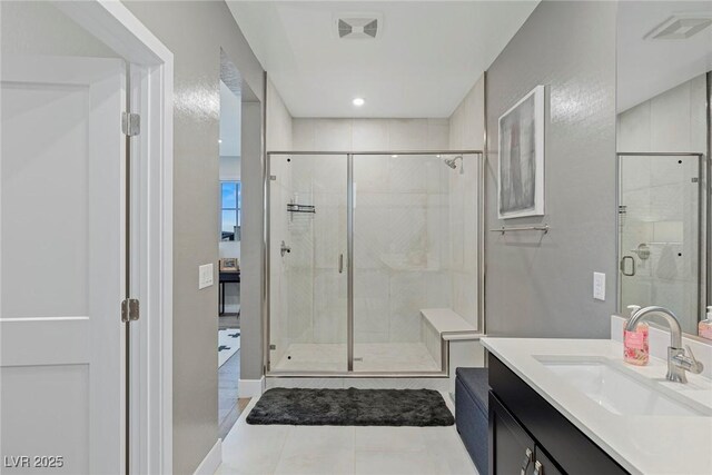 bathroom featuring a shower with door, vanity, and tile patterned floors