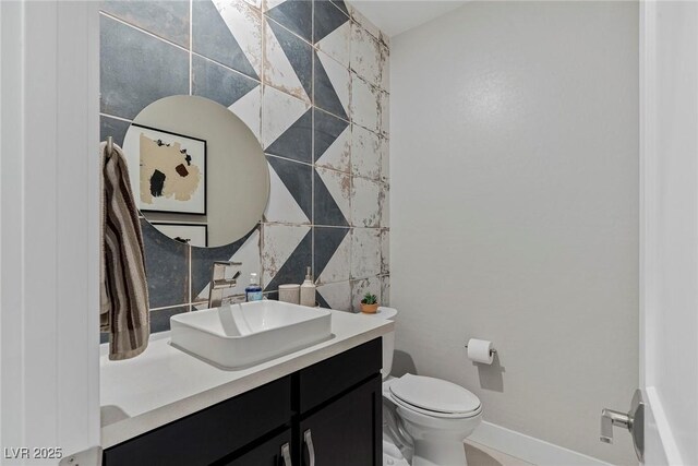 bathroom with toilet, vanity, and tile walls