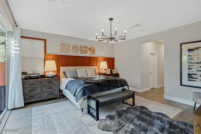 bedroom featuring light wood-type flooring and an inviting chandelier