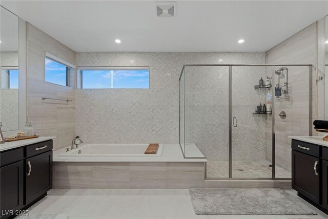 bathroom featuring independent shower and bath, tile patterned flooring, and vanity