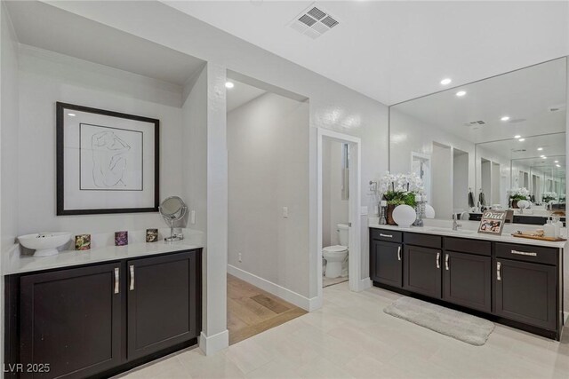 bathroom featuring tile patterned flooring, vanity, and toilet