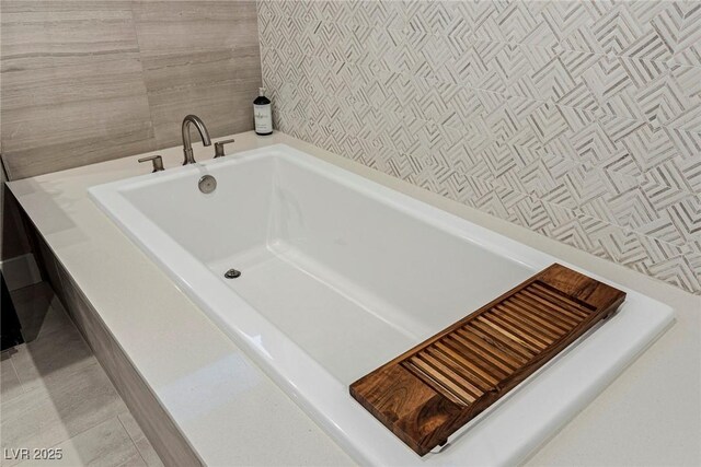 bathroom featuring tile patterned floors and a bath