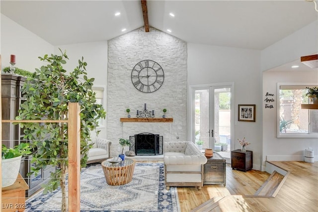 living room with a fireplace, light wood-type flooring, french doors, and vaulted ceiling with beams