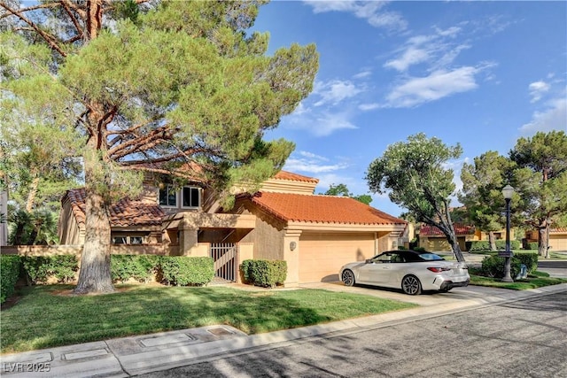 mediterranean / spanish house featuring a front yard and a garage