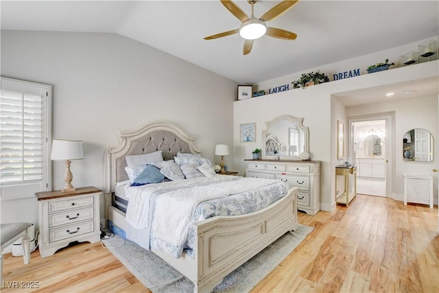 bedroom with ceiling fan, light wood-type flooring, ensuite bath, and lofted ceiling