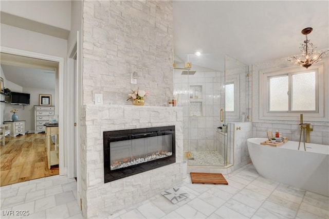 bathroom featuring lofted ceiling, independent shower and bath, and a stone fireplace