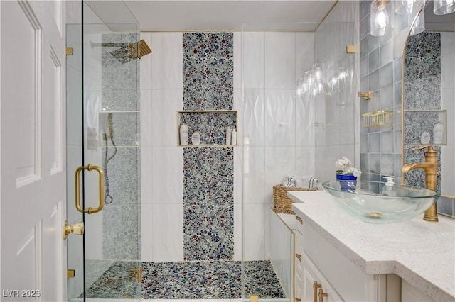 bathroom with tile walls, a shower with door, and vanity