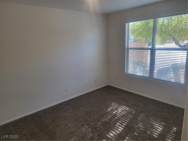 empty room featuring a healthy amount of sunlight and dark carpet