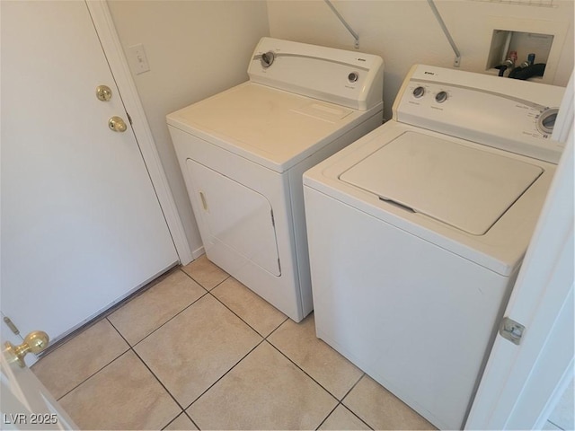 laundry room with washer and clothes dryer and light tile patterned floors