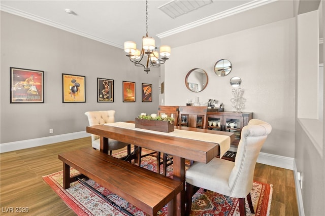 dining space featuring wood-type flooring, a chandelier, and ornamental molding