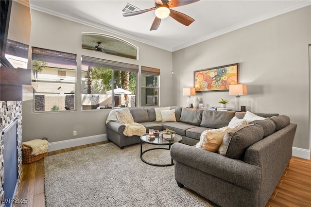 living room featuring a stone fireplace, ceiling fan, crown molding, and hardwood / wood-style floors