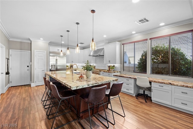 dining area featuring sink, ornamental molding, built in desk, and hardwood / wood-style floors