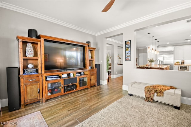 living room with ceiling fan, crown molding, and light hardwood / wood-style flooring