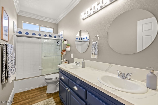 full bathroom featuring toilet, shower / bath combination with glass door, vanity, and ornamental molding