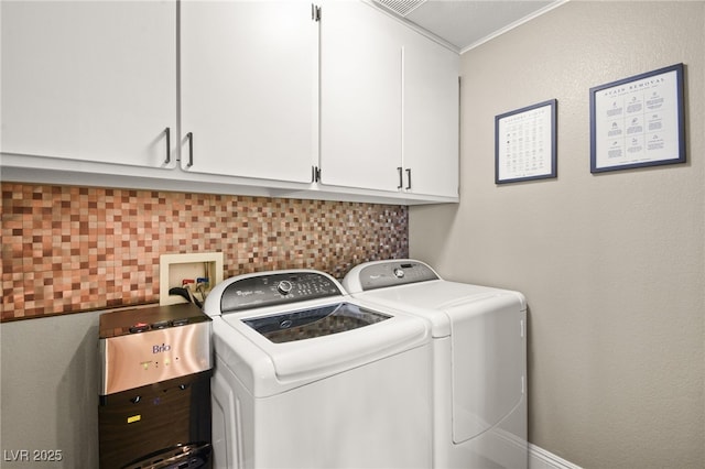 clothes washing area featuring cabinets and independent washer and dryer