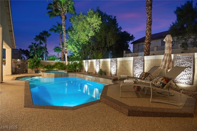 pool at dusk with an in ground hot tub