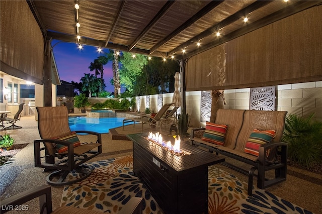 patio terrace at dusk with a fenced in pool and a fire pit