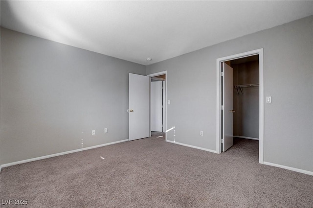 unfurnished bedroom featuring a spacious closet, a closet, and carpet floors