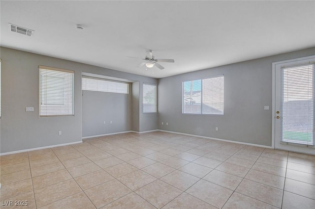 spare room featuring ceiling fan, light tile patterned flooring, and plenty of natural light