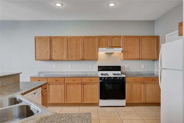 kitchen featuring sink, range with gas cooktop, white fridge, light tile patterned floors, and light brown cabinetry