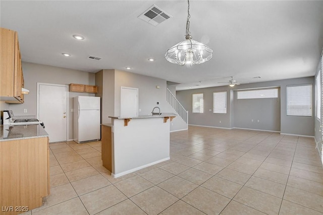 kitchen with white fridge, hanging light fixtures, light tile patterned floors, ceiling fan, and stove