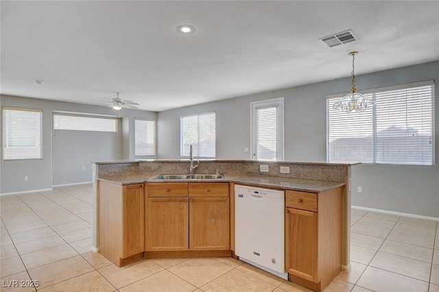 kitchen featuring hanging light fixtures, an island with sink, ceiling fan with notable chandelier, white dishwasher, and sink