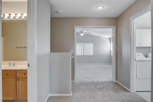 bathroom featuring ceiling fan, washer / clothes dryer, vaulted ceiling, and vanity