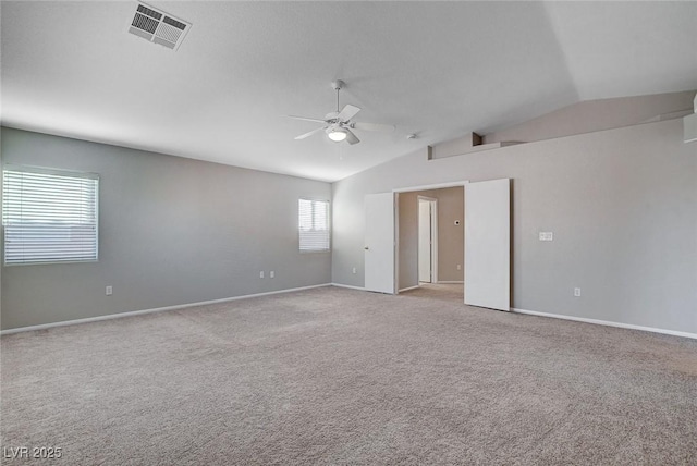 spare room with lofted ceiling, light colored carpet, and ceiling fan