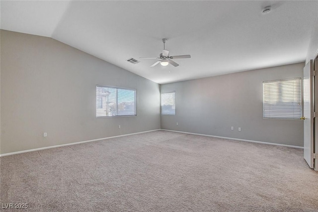 carpeted spare room with ceiling fan and vaulted ceiling