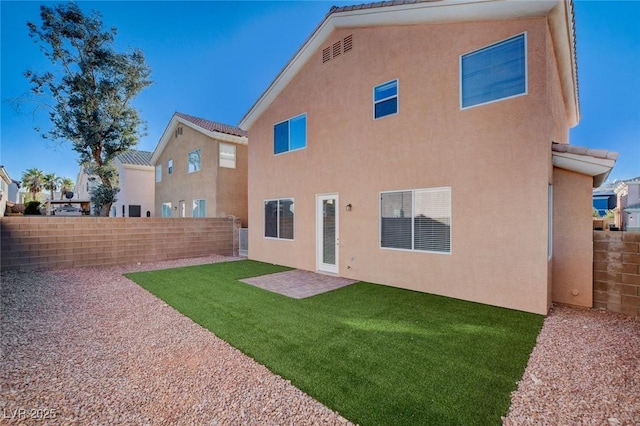 rear view of house featuring a lawn and a patio area