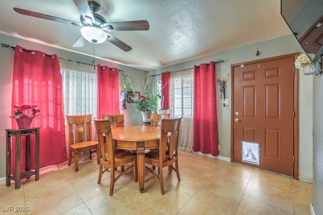 dining space featuring ceiling fan and a textured ceiling