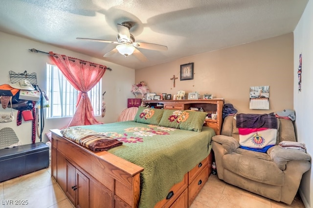 tiled bedroom featuring ceiling fan and a textured ceiling