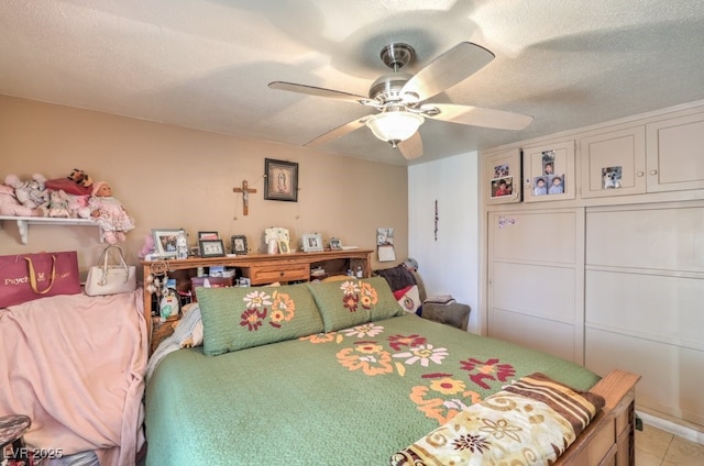 bedroom with a closet, light tile patterned flooring, a textured ceiling, and ceiling fan