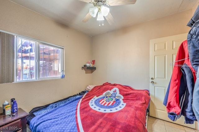 tiled bedroom featuring ceiling fan