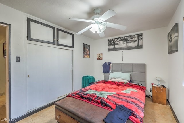 bedroom featuring ceiling fan, a closet, and light tile patterned floors