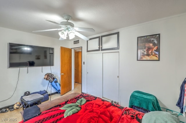 carpeted bedroom with a textured ceiling, ceiling fan, and ornamental molding