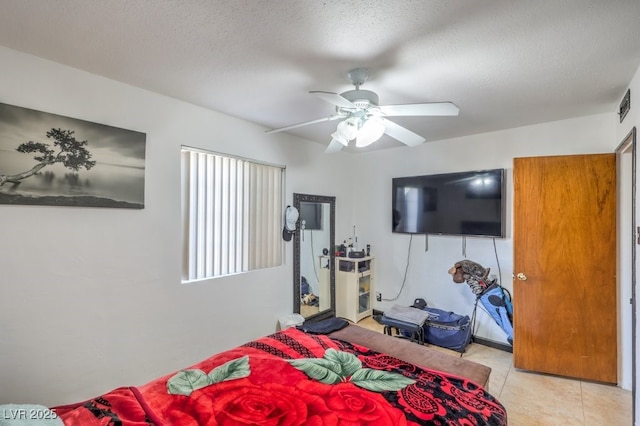 tiled bedroom featuring a textured ceiling and ceiling fan