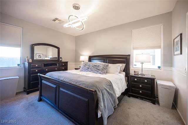 bedroom featuring an inviting chandelier, light carpet, and multiple windows