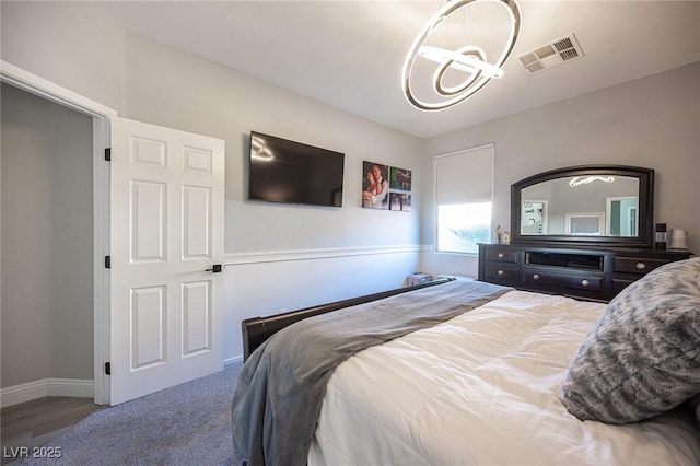 bedroom featuring carpet flooring and a chandelier