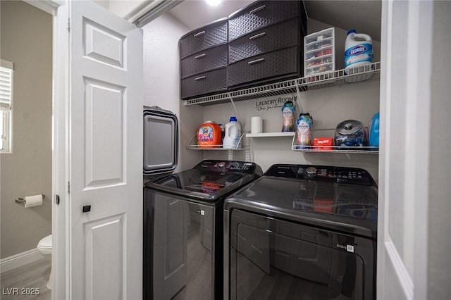 laundry area with washing machine and clothes dryer and hardwood / wood-style floors