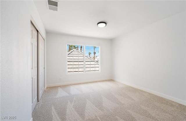 unfurnished bedroom with light colored carpet and a closet