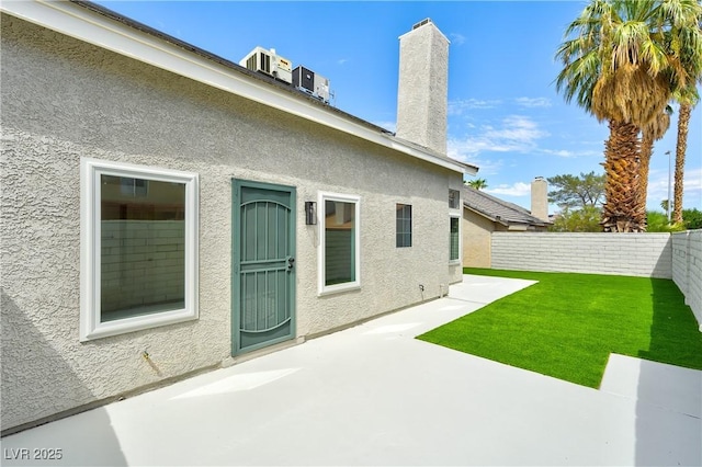 rear view of house featuring central AC, a patio area, and a yard